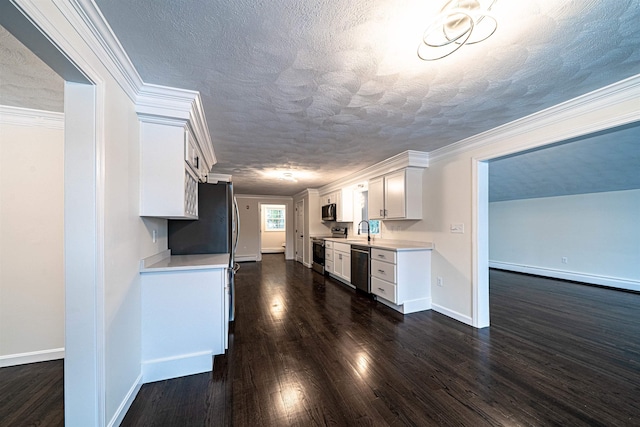 kitchen with crown molding, stainless steel appliances, light countertops, dark wood-type flooring, and a sink