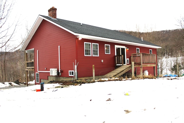 view of front of home with ac unit, a chimney, stairway, and a wooden deck