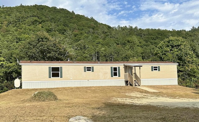 manufactured / mobile home with entry steps and a view of trees