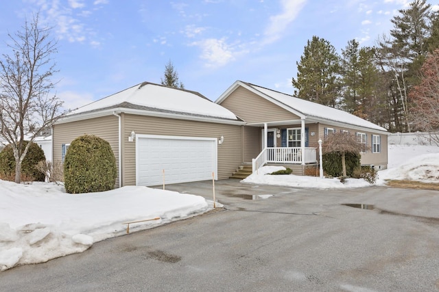 ranch-style house with covered porch, driveway, and an attached garage