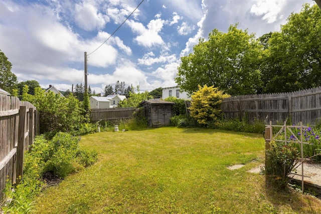 view of yard with a storage unit, an outdoor structure, and a fenced backyard