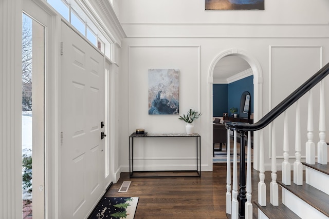 entryway featuring a healthy amount of sunlight, visible vents, dark wood-style flooring, and crown molding