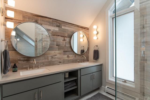 bathroom featuring a baseboard heating unit, double vanity, backsplash, and a sink