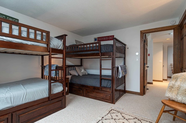 carpeted bedroom featuring baseboards and a textured ceiling