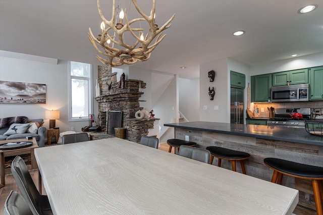 dining area with a fireplace, stairway, and recessed lighting