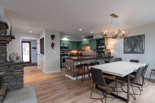 dining area featuring light wood finished floors, recessed lighting, and baseboards