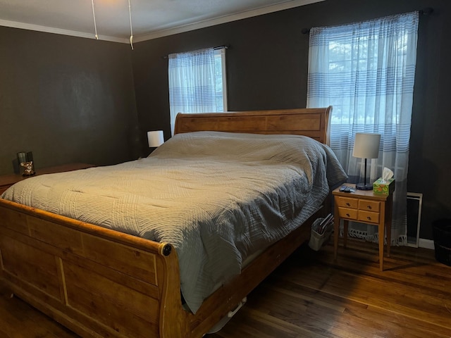 bedroom with crown molding and wood finished floors