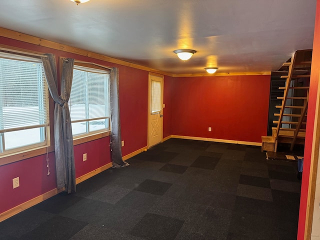 spare room with baseboards and stairs