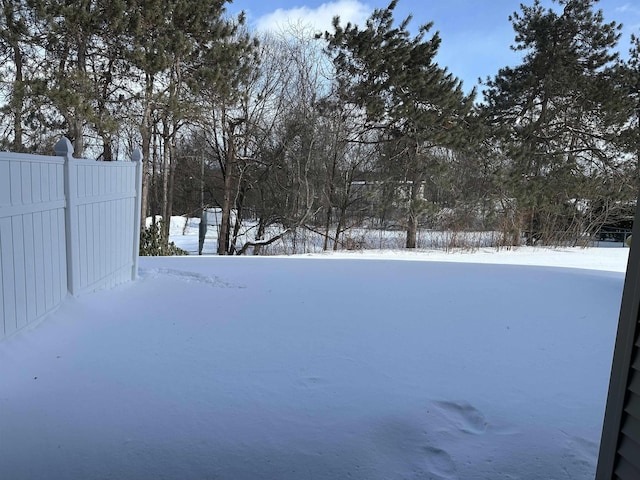 yard layered in snow with fence