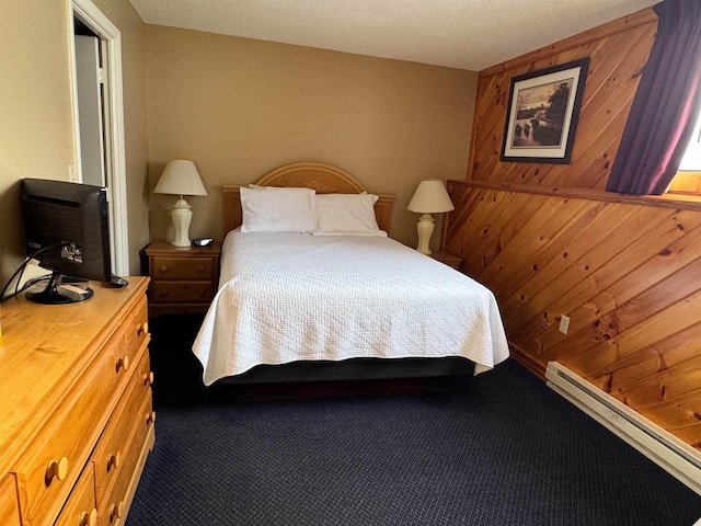 bedroom featuring a baseboard heating unit, carpet floors, and wooden walls