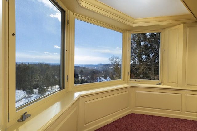 details with carpet flooring, a mountain view, and a decorative wall