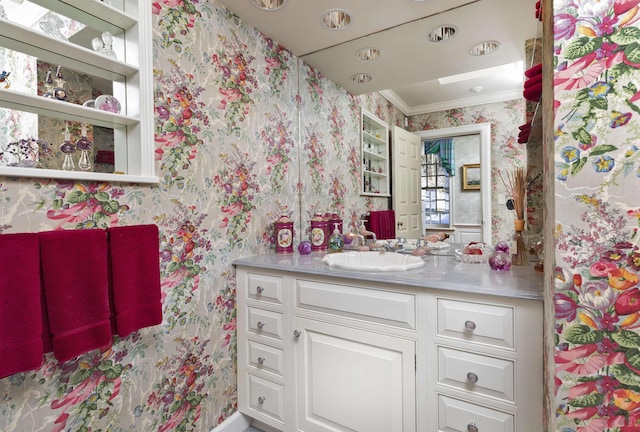 bathroom featuring wallpapered walls, ornamental molding, and vanity