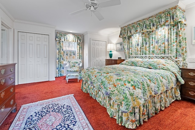 bedroom with ceiling fan, carpet flooring, two closets, and crown molding