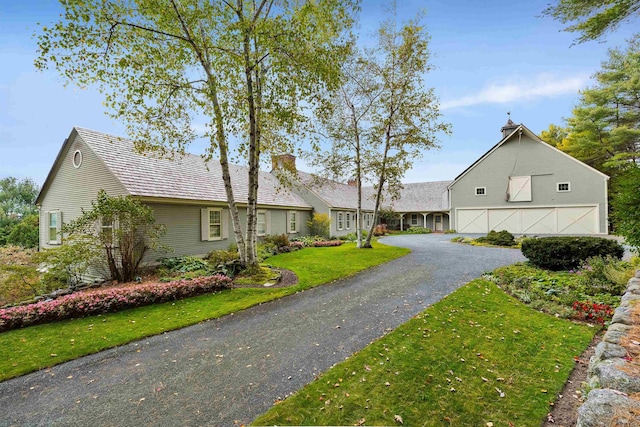 view of front of property featuring aphalt driveway and a front lawn