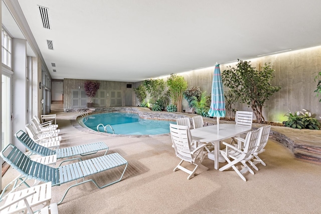 indoor pool featuring a patio area and outdoor dining area