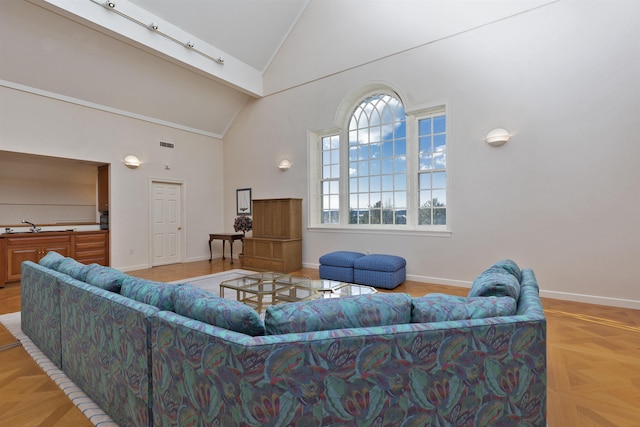 living area featuring high vaulted ceiling, visible vents, and baseboards