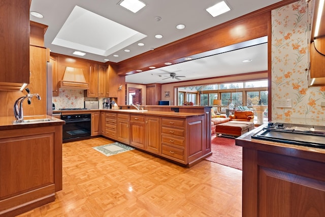 kitchen with a peninsula, custom exhaust hood, gas cooktop, a sink, and black oven