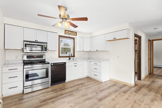 kitchen featuring stainless steel appliances, light wood-type flooring, a sink, and light countertops