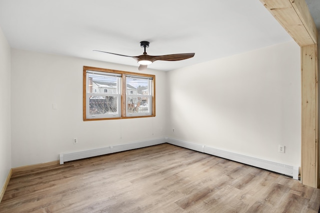 spare room with a baseboard radiator, wood finished floors, and a ceiling fan