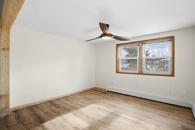 unfurnished room with a baseboard radiator, wood finished floors, a ceiling fan, and baseboards