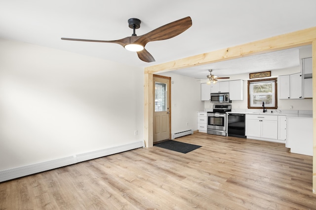 kitchen with a baseboard radiator, light wood-style flooring, appliances with stainless steel finishes, baseboard heating, and light countertops