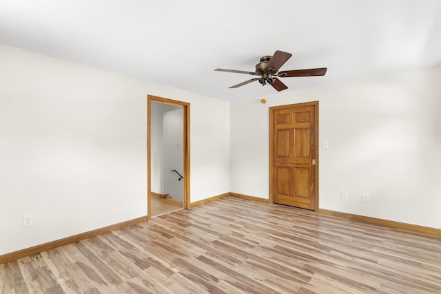 spare room with ceiling fan, light wood-style flooring, and baseboards