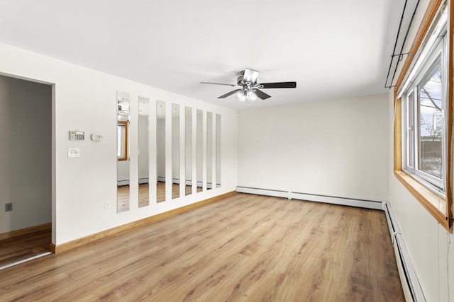 spare room with a ceiling fan, baseboards, baseboard heating, and wood finished floors