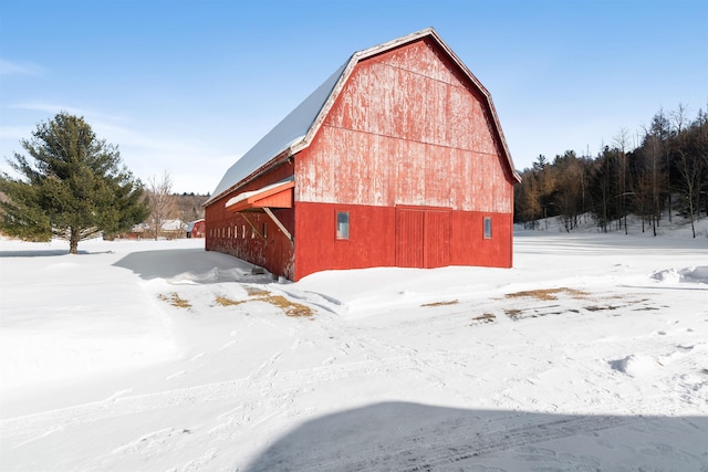 snow covered structure with an outbuilding and a barn