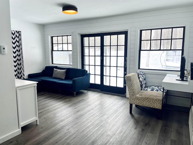 living area featuring a wealth of natural light, baseboards, and wood finished floors