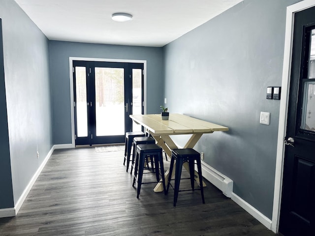 dining space with dark wood finished floors and baseboards