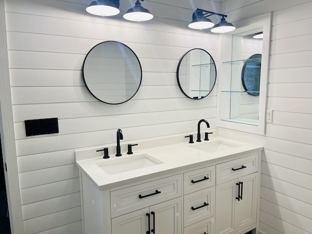 bathroom with double vanity, wood walls, and a sink
