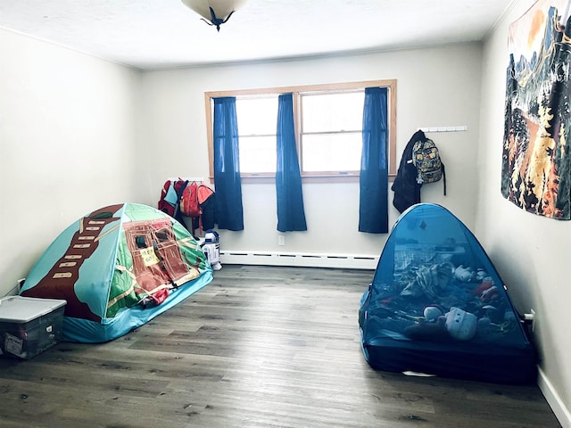 bedroom featuring a baseboard radiator and wood finished floors