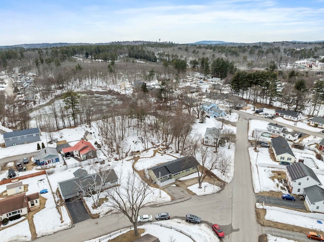 snowy aerial view with a mountain view and a residential view