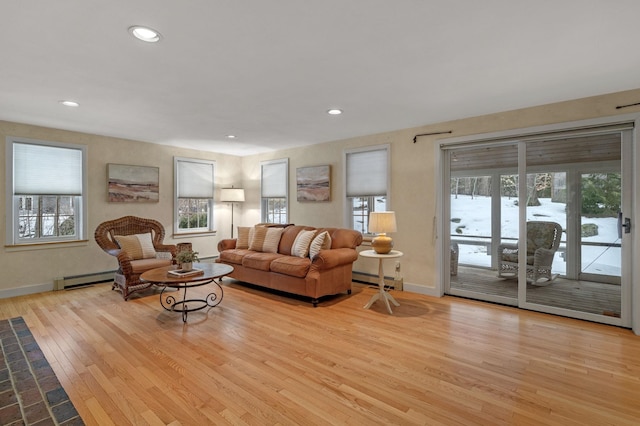 living room with a baseboard heating unit, hardwood / wood-style floors, baseboards, and recessed lighting