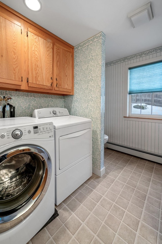 laundry room with light tile patterned floors, a baseboard radiator, washing machine and dryer, and cabinet space