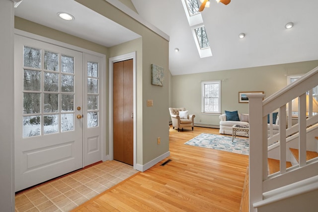 entryway with baseboards, a baseboard radiator, stairway, light wood-type flooring, and recessed lighting