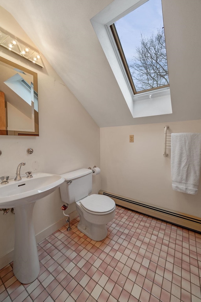 bathroom with a baseboard radiator, toilet, tile patterned flooring, vaulted ceiling with skylight, and baseboards