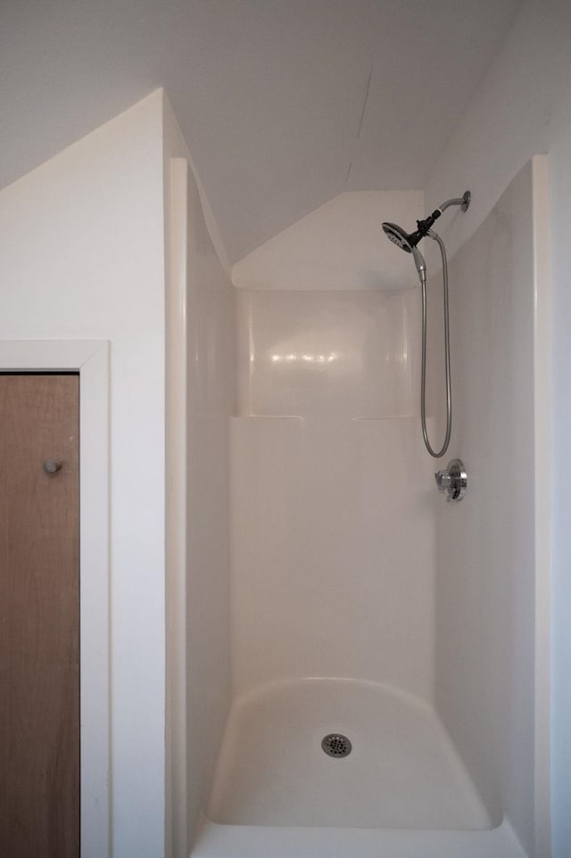 bathroom featuring a shower and lofted ceiling