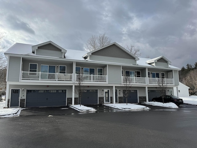 view of front facade featuring an attached garage, stone siding, and driveway