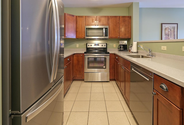 kitchen featuring light tile patterned floors, appliances with stainless steel finishes, light countertops, and a sink