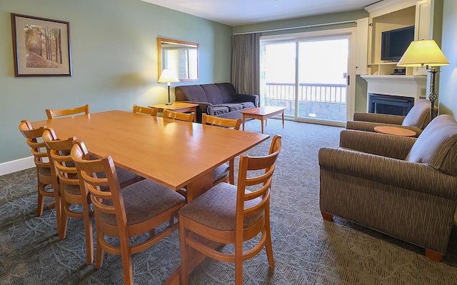 carpeted dining space featuring a fireplace and baseboards