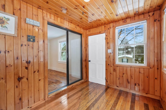 entryway with wood walls, wood-type flooring, wood ceiling, and baseboards