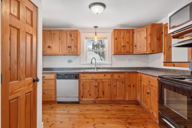 kitchen featuring electric range, dark countertops, dishwashing machine, stainless steel microwave, and a sink