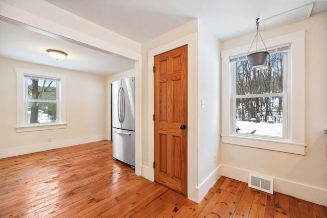 kitchen featuring light wood-style floors, freestanding refrigerator, a healthy amount of sunlight, and visible vents