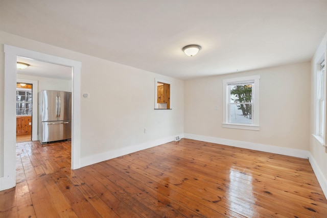 empty room featuring wood-type flooring and baseboards