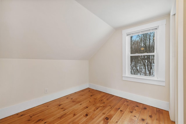 bonus room with lofted ceiling, wood-type flooring, and baseboards