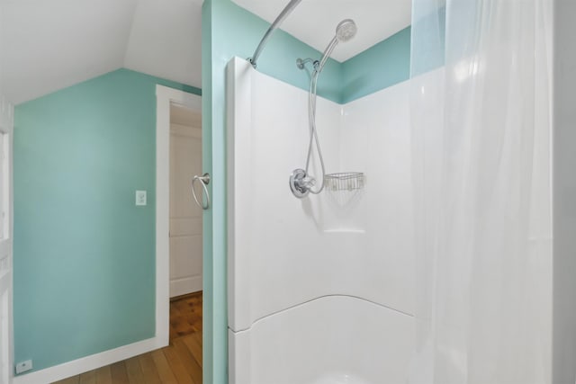 full bath featuring lofted ceiling, baseboards, a shower with shower curtain, and wood finished floors