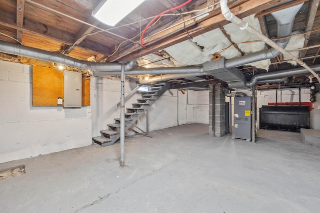 unfinished basement featuring stairway, heating fuel, electric panel, and heating unit