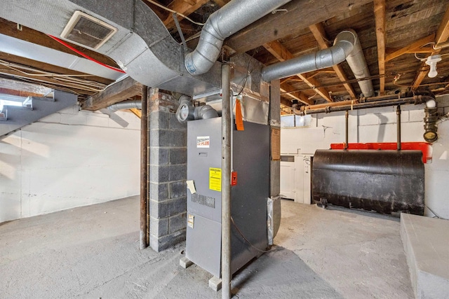 utility room with heating unit, heating fuel, and visible vents