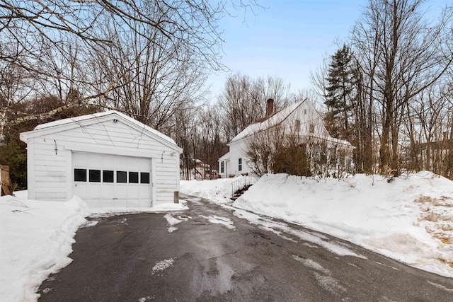 exterior space featuring a detached garage and aphalt driveway